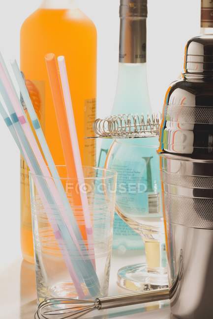 Vista de perto do equipamento de coquetel com copos, bebidas, palhas e coqueteleira — Fotografia de Stock