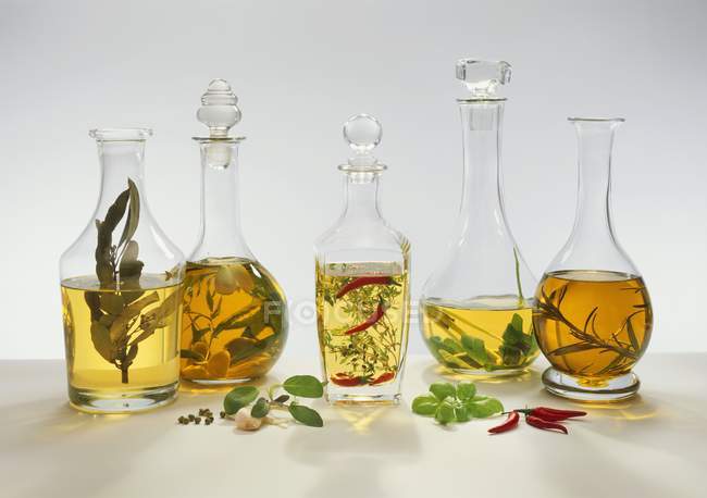 Fünf verschiedene aromatisierte Essige auf weißem Hintergrund — Stockfoto