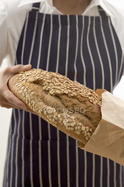 Woman putting bread into bag — Stock Photo