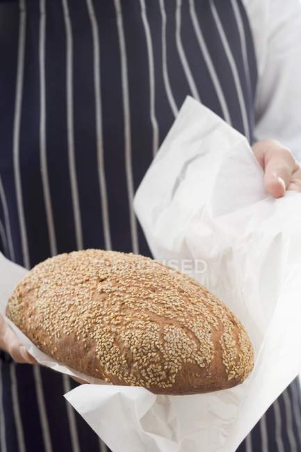 Woman holding loaf of oat bread — Stock Photo
