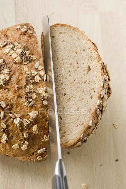 Halving a loaf of bread — Stock Photo