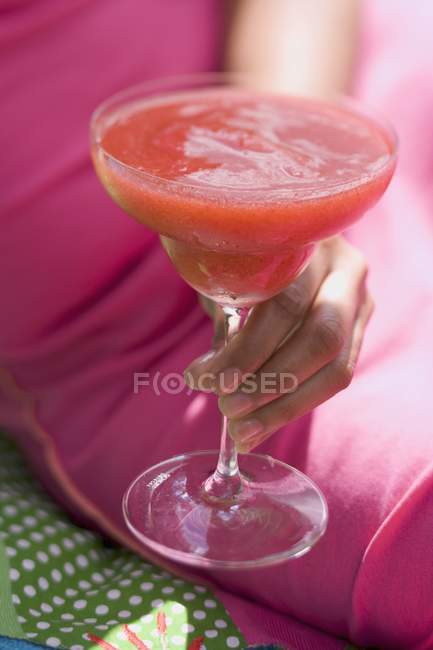 Closeup cropped view of woman holding fruity strawberry drink — Stock Photo