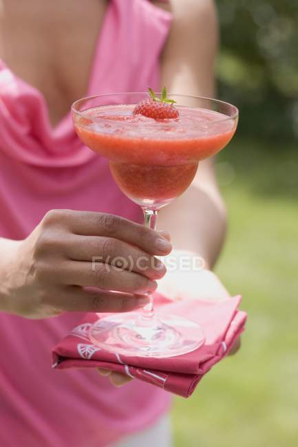 Closeup cropped view of woman holding fruity strawberry drink — Stock Photo