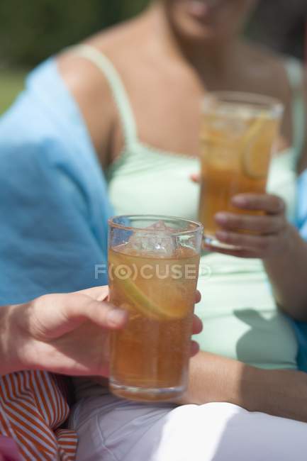 Дневной вид на двух женщин, держащих стаканы чая со льдом — стоковое фото