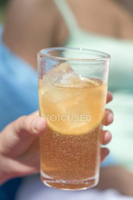 Vue rapprochée du verre de thé glacé tenu à la main — Photo de stock