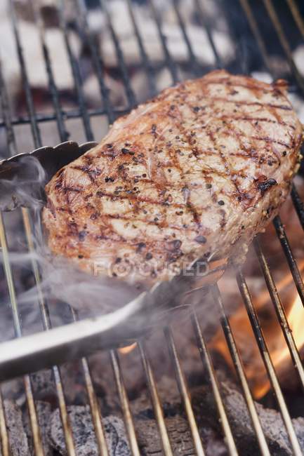 Moking barbecue with tongs — Stock Photo