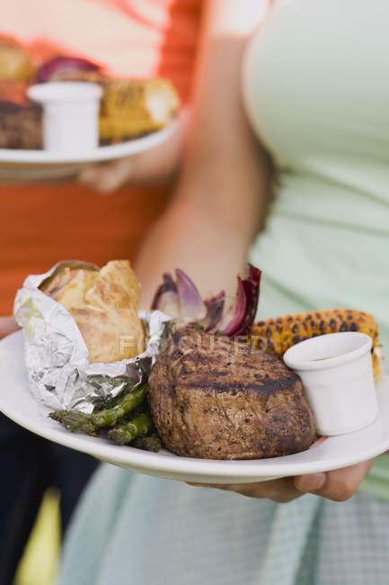 Dos mujeres sosteniendo platos - foto de stock