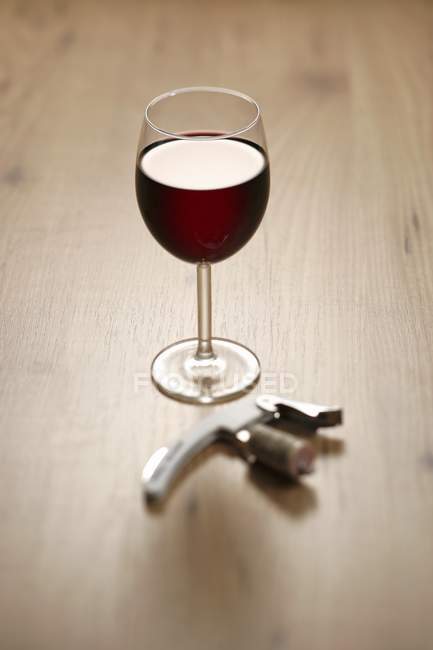 Copa de vino tinto con sacacorchos - foto de stock
