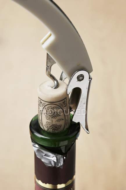 Closeup view of bottle of red wine with corkscrew — Stock Photo