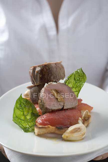 Woman holding plate with pork fillet — Stock Photo