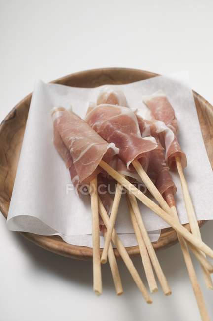 Grissini wrapped in raw ham — Stock Photo