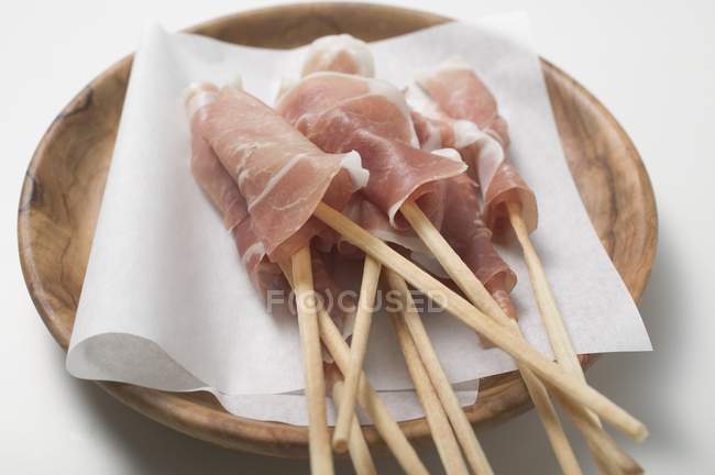 Grissini wrapped in raw ham — Stock Photo