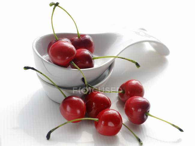 Several cherries with porcelain spoons — Stock Photo