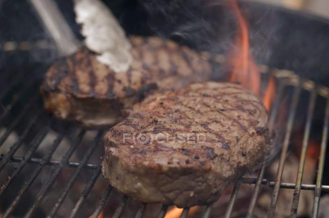 Beef steaks on barbecue — Stock Photo