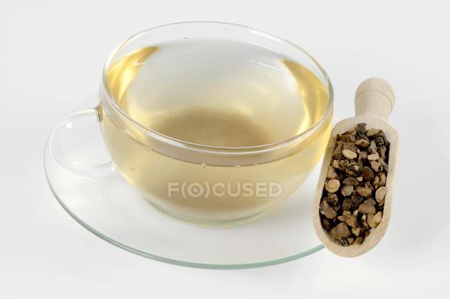 Cup of tea with dried nutgrass root — Stock Photo