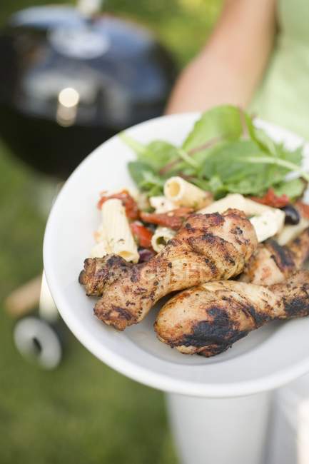 Grilled chicken legs and pasta salad — Stock Photo
