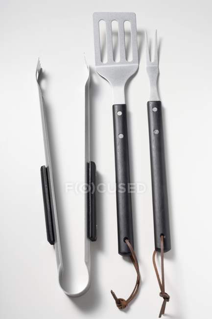 Closeup top view of barbecue tools on white surface — Stock Photo