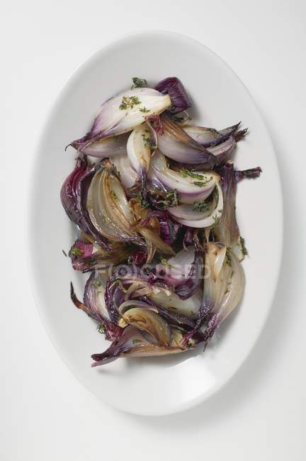 Cipolle rosse grigliate su piatto bianco — Foto stock