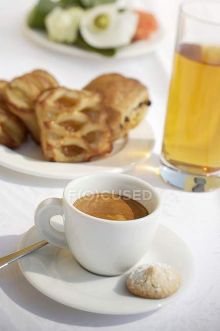 Taza de espresso con zumo y pasteles - foto de stock