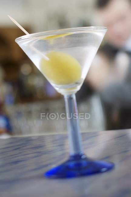 Пейте с оливками на барной стойке — стоковое фото