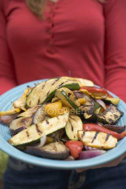 Donna che tiene in mano un piatto di verdure alla griglia, sezione centrale — Foto stock