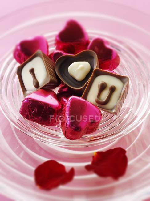 Chocolates on red fabric — Stock Photo