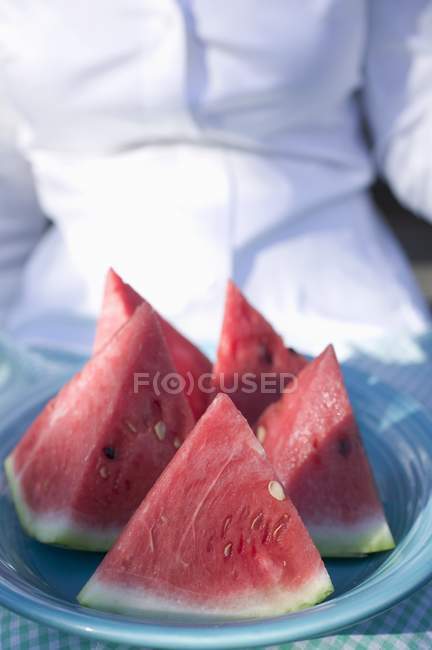 Woman holding plate of watermelon — Stock Photo