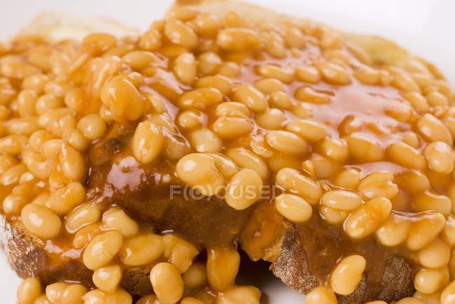 Two slices of beans on toast on white surface — Stock Photo