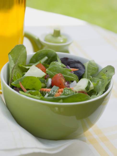 Gemischter Salat in grüner Schüssel über Textiltuch — Stockfoto