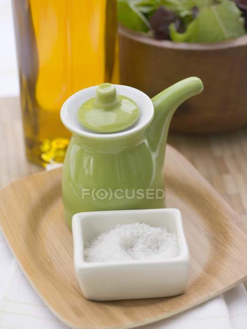 Sal com jarro verde pequeno e salada de folha — Fotografia de Stock
