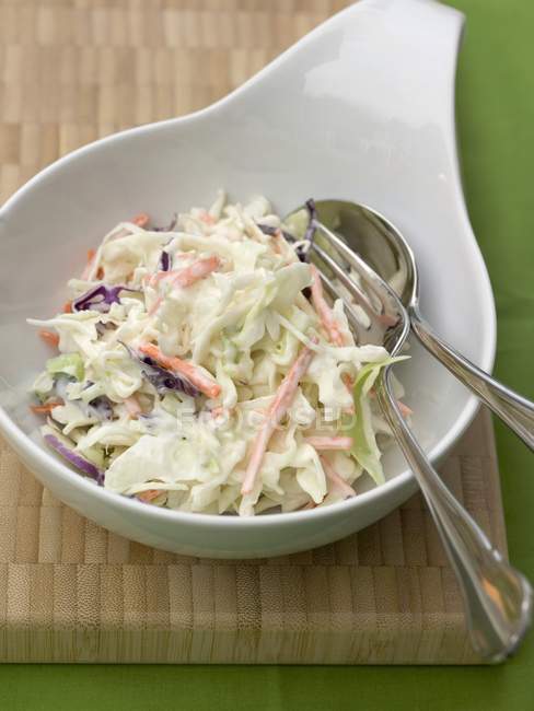 Coleslaw - cabbage saladin white bowl with cutlery on green surface — Stock Photo