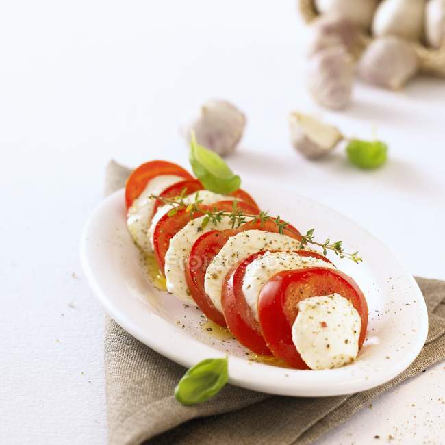 Tomato and mozzarella with herbs — Stock Photo