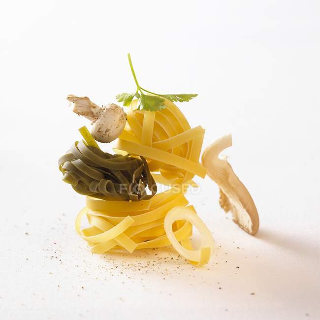 Rohe Tagliatelle-Nester mit Pilzen — Stockfoto