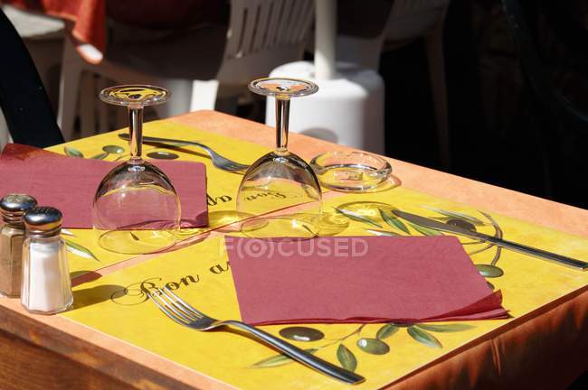 Vista elevada diurna da tabela posta com guardanapos, rodízios, copos e talheres — Fotografia de Stock