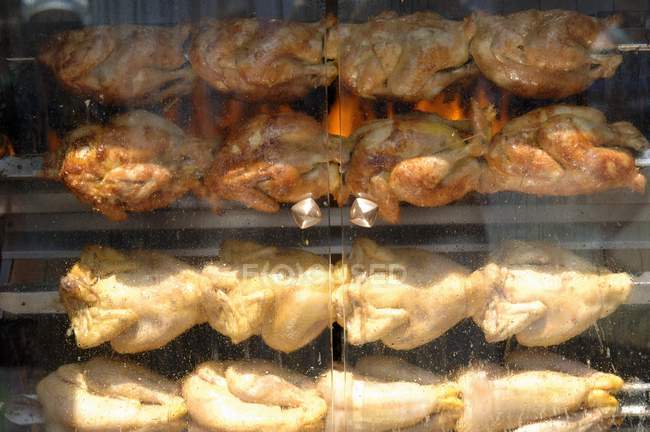 Vue rapprochée des poulets à griller sur les broches — Photo de stock