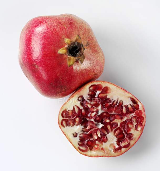 Whole and halved pomegranate — Stock Photo