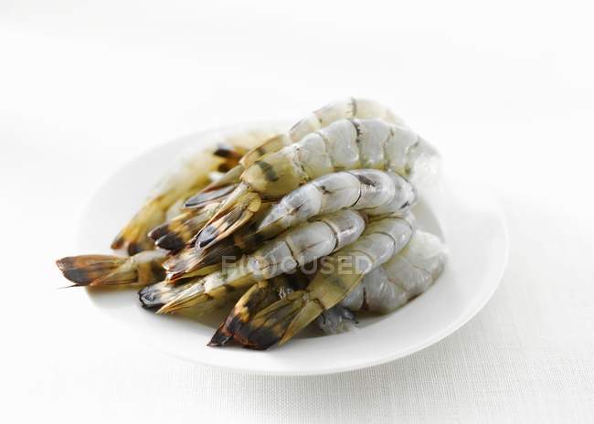 Raw peeled prawns on plate — Stock Photo