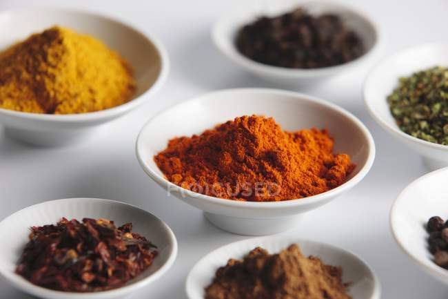 Closeup view of various exotic spices in porcelain dishes — Stock Photo