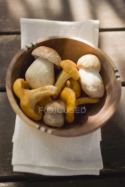 Chanterelles and ceps in wooden bowl — Stock Photo