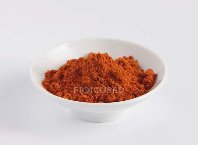 Pó de caril vermelho em prato de porcelana — Fotografia de Stock