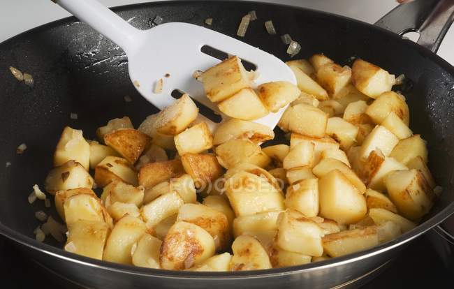 Fried potatoes with onions in frying pan — Stock Photo