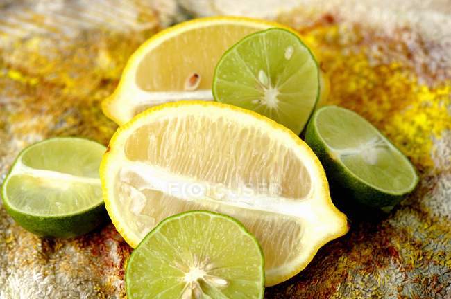 Citrons verts et citrons coupés en deux — Photo de stock