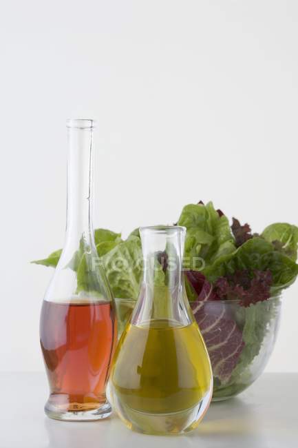 Vue rapprochée de l'huile et du vinaigre dans les carafes devant le saladier — Photo de stock