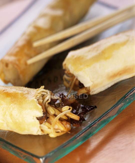 Vegetable spring rolls on glass plate with chopsticks — Stock Photo
