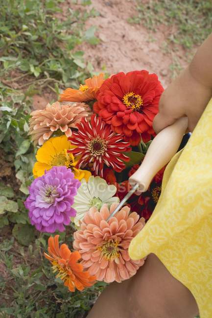 Visão elevada diurna da criança segurando um balde de flores de verão — Fotografia de Stock