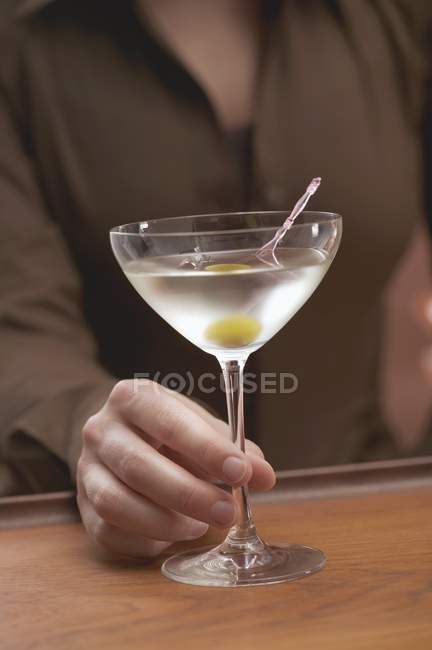 Bar tender offering glass of martini — Stock Photo