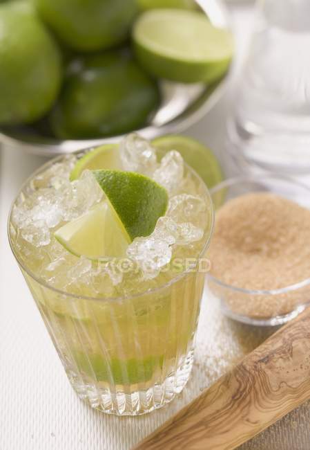Caipirinha with lime and cane sugar — Stock Photo