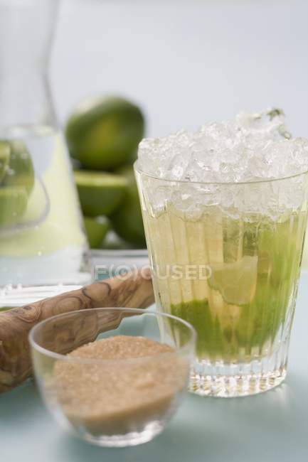 Caipirinha with lime and cane sugar — Stock Photo