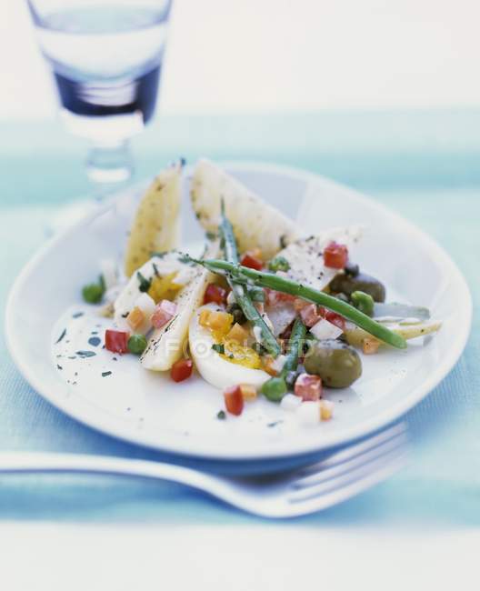 Яйцо и овощной салат с картошкой на белой тарелке — стоковое фото