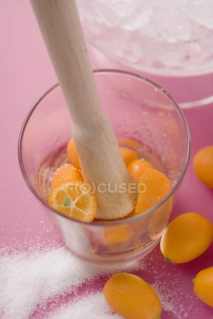 Aplastar kumquats en un vaso - foto de stock